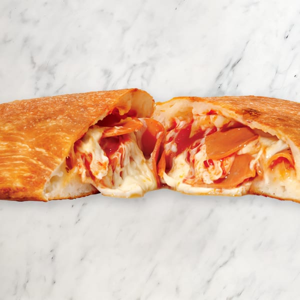 A Pizza Nova panzerotti, cut open to reveal melted cheese, pepperoni, and tomato sauce.